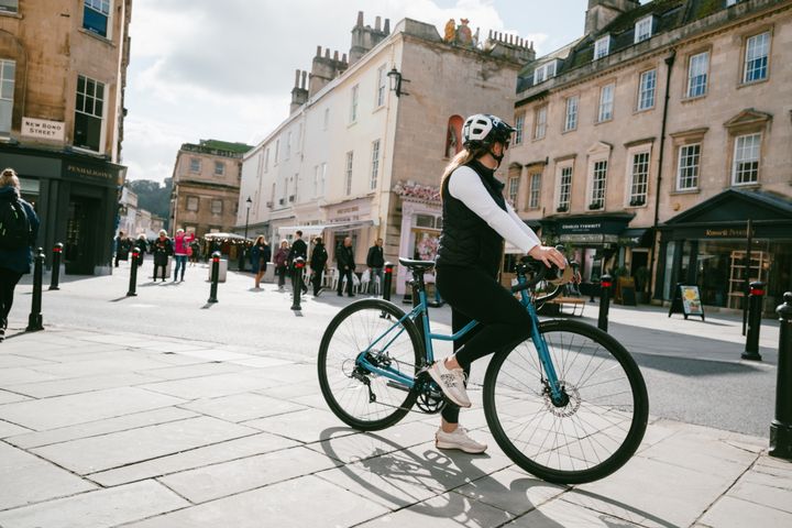 Cycliste roulant sur un Marin Nicasio 1 ST 2025 coloris Blue en centre-ville, profitant du cadre ouvert et d'une position confortable pour ses déplacements urbains.