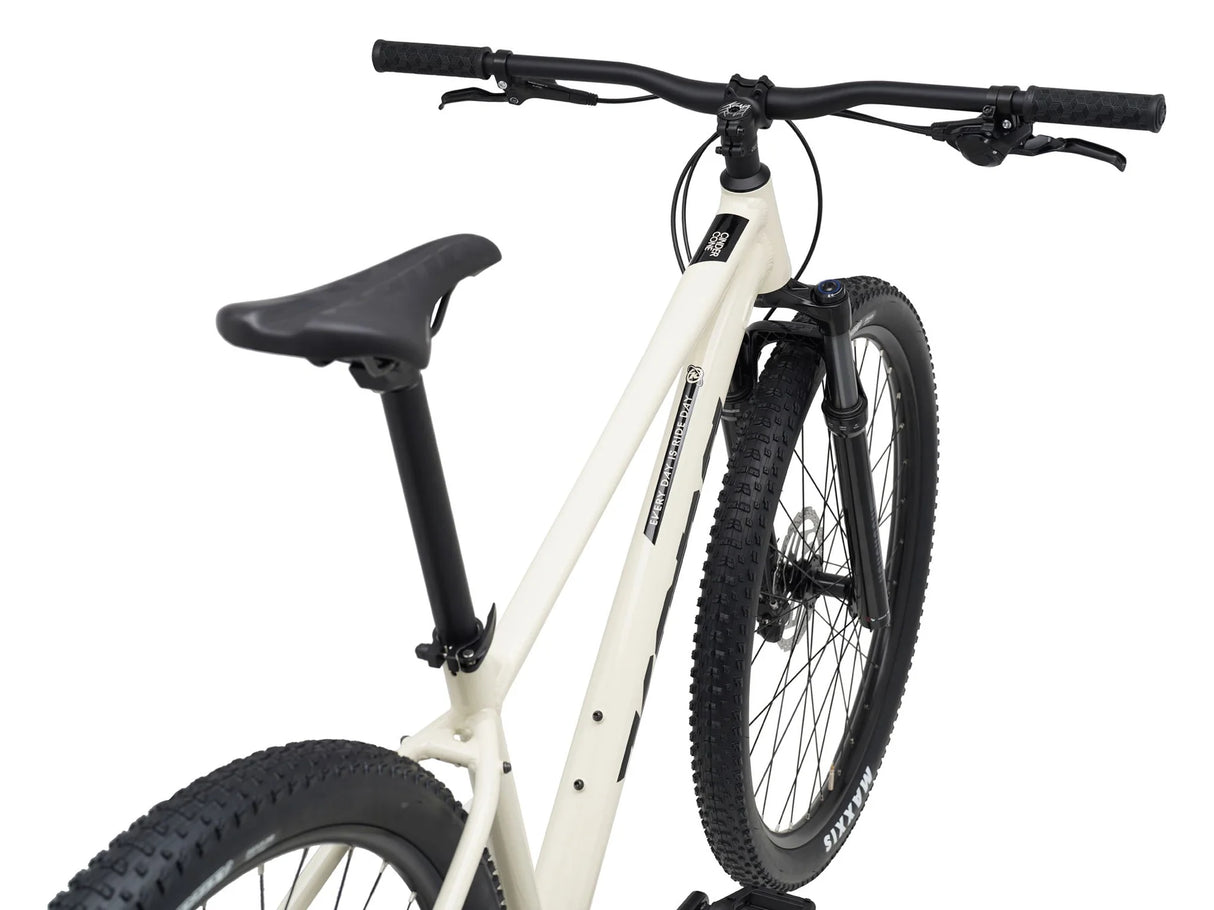 Kona Cinder Cone 2026 en plongée arrière : guidon, selle et pneus Maxxis Rekon bien visibles.