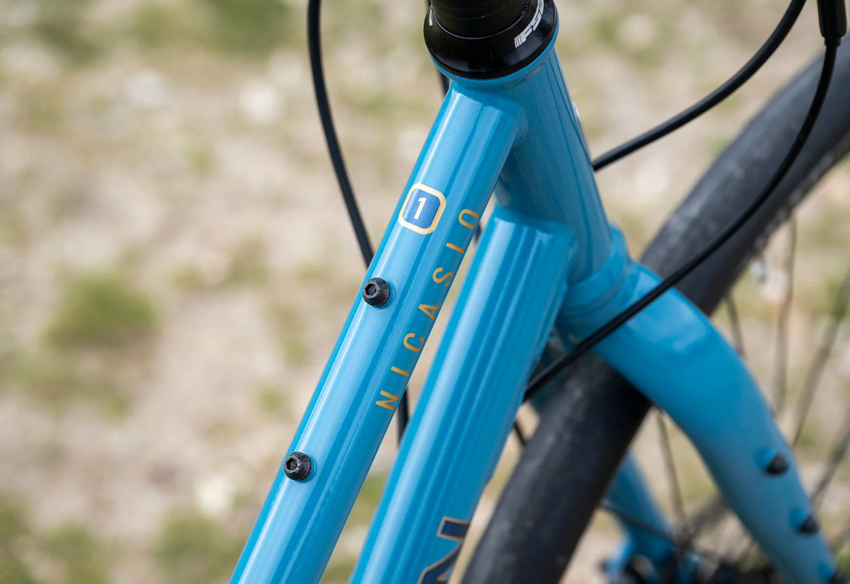 Détail du tube supérieur abaissé et des fixations du cadre ouvert du Marin Nicasio 1 ST 2025. Elles vous permettent d'ajouter porte-bagages, garde-boue et accessoires pour vos trajets du quotidien.