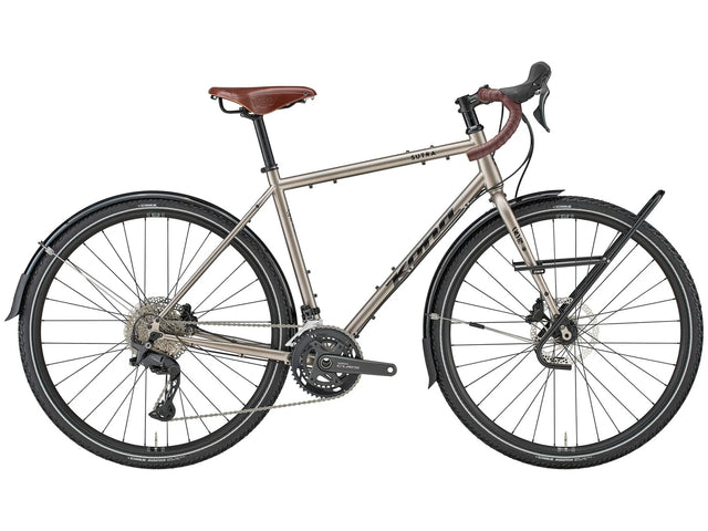 Vélo de cyclotourisme Kona Sutra en acier, coloris Gloss Metallic Nickel, vue latérale complète montrant le cadre Cromoly, les garde-boue complets et le porte-bagages avant Tubus.
