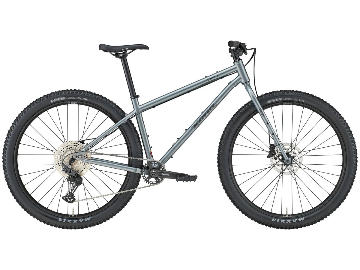 Vélo de montagne rigide Kona Unit X en acier, coloris Gloss Metallic Dark Faux Raw, vue latérale complète montrant le cadre Reynolds 520 Cromoly et les roues 29 pouces.