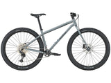 Vélo de montagne rigide Kona Unit X en acier, coloris Gloss Metallic Dark Faux Raw, vue latérale complète montrant le cadre Reynolds 520 Cromoly et les roues 29 pouces.