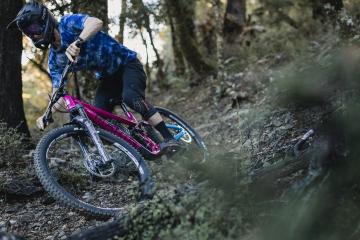 Cycliste dévalant un sentier technique sur un vélo de montagne Marin Alpine Trail, scène d'action en pleine nature