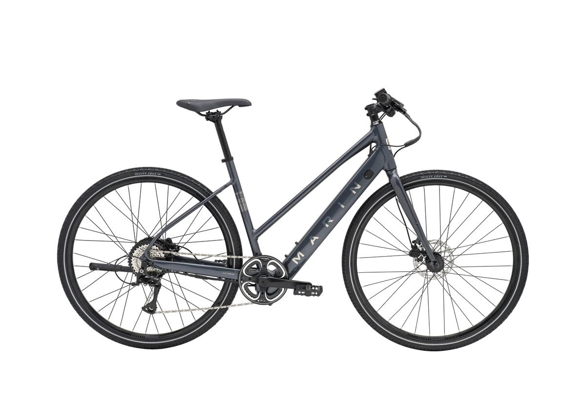 Vélo hybride électrique urbain Marin Fairfax Electric ST 2026 à cadre ouvert, coloris Charcoal, vue latérale complète montrant le cadre Series 1 en aluminium, la batterie intégrée au tube diagonal et les pneus Vee Tire City Cruz 700x40c.