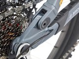 Gros plan du pneu avant Maxxis Assegai 29x2.5 monté sur jante WTB HTZ Trail i30 du Kona Remote X, pour accrocher dans la terre meuble, les racines humides et les roches.