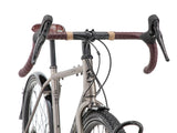 Détail du poste de pilotage du Kona Sutra : cintre gravel Kona, poignées Brooks microfibre et commandes intégrées Shimano CUES à portée de main.