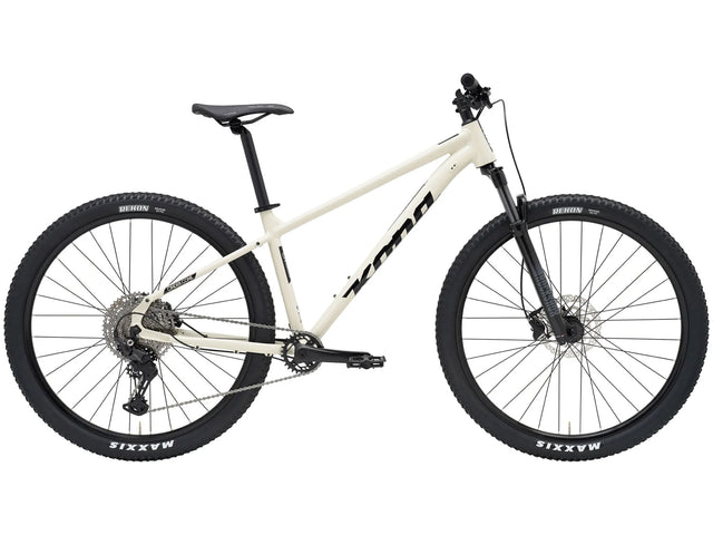VTT Kona Cinder Cone 2026, cadre crème, fourche RockShox et pneus Maxxis Rekon 29", profil complet.